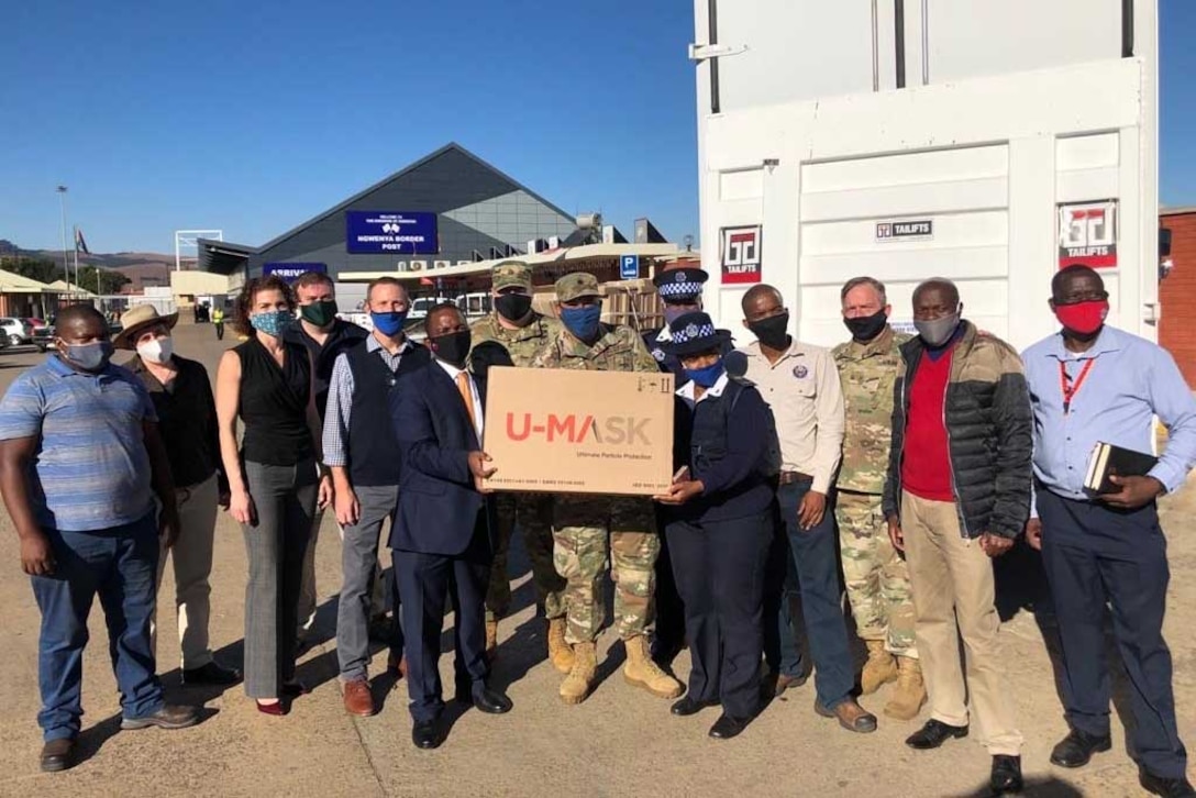 Service members and civilians pose for a group photo.