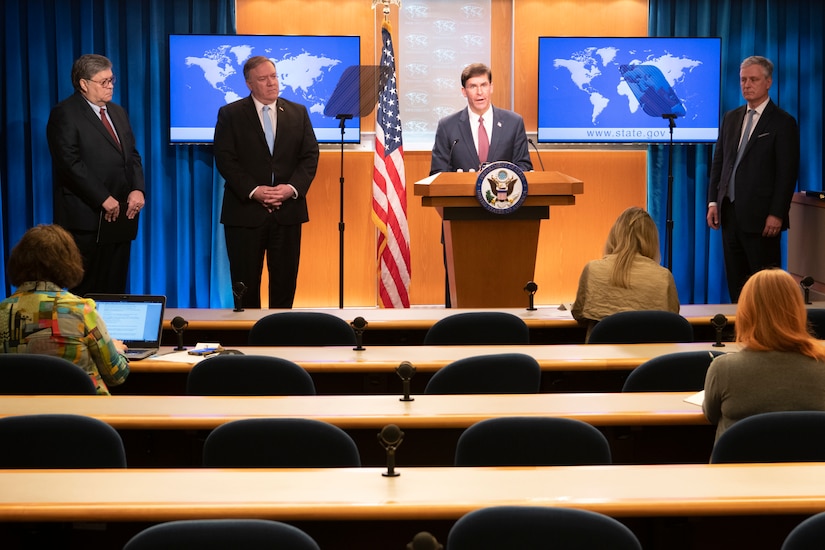 Defense Secretary Dr. Mark T. Esper speaks at a lectern as other leaders stand around him.