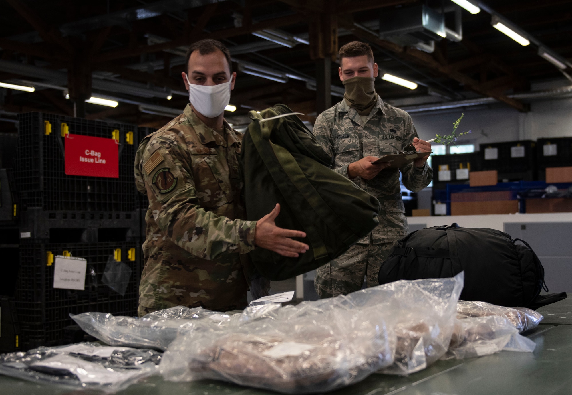 U.S. Air Force Tech Sgt. Mark Majack, left, 52nd Logistics Readiness Squadron section chief of personal property, passenger travel office, and Airman 1st Class Joshua Boozer, right, 52nd LRS Individual Protective Equipment apprentice, demonstrate putting a deployment bag together, June 4, 2020, at Spangdahlem Air Base, Germany. The 52nd LRS IPE Airmen are responsible for ensuring Airmen are properly equipped with gear needed for taskings, deployments, and temporary duty travel. (U.S. Air Force photo by Senior Airman Melody W. Howley)