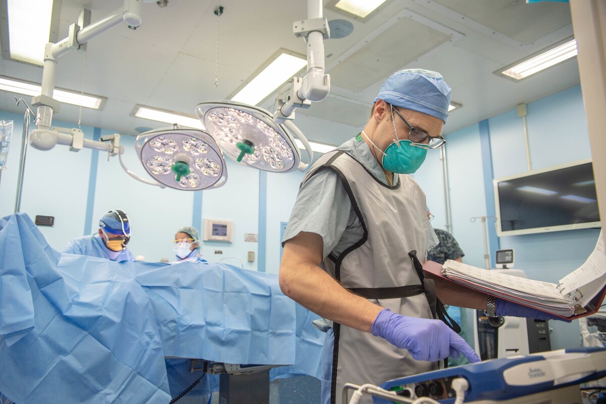 Doctors and medics work in a ship’s operating room.