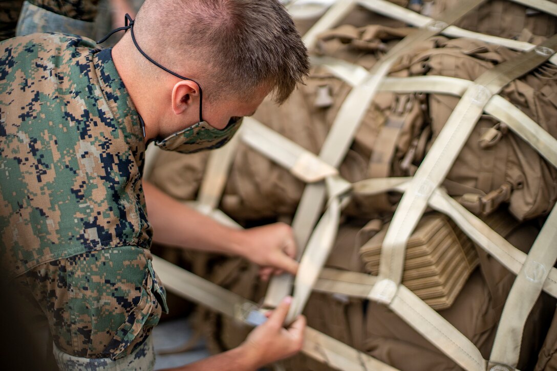Lance Cpl. Alec Pomeroy, an embarkation clerk with Special Purpose Marine Air-Ground Task Force - Southern Command, secures gear with straps during a strategic mobility exercise at Marine Corps Air Station Cherry Point, North Carolina, May 29, 2020. SPMAGTF-SC Marines and Sailors conducted a MOBEX to validate the unit’s ability to rapidly and effectively deploy to Latin America and the Caribbean for crisis response efforts. The MOBEX will help the task force identify any resource shortfalls required to deploy from Camp Lejeune, North Carolina, to U.S. Southern Command’s area of operations, and give the service members an opportunity to demonstrate their ability to rapidly deploy at a moment’s notice. Pomeroy is native of a Duvall, Washington. (U.S. Marine Corps photo by Sgt. Andy O. Martinez)