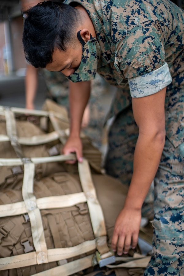 Cpl. Benjamin Capuli, an embarkation clerk with Special Purpose Marine Air-Ground Task Force - Southern Command, secures gear with straps during a strategic mobility exercise at Marine Corps Air Station Cherry Point, North Carolina, May 29, 2020. The SPMAGTF-SC Marines and Sailors conducted a MOBEX to validate the unit’s ability to rapidly and effectively deploy to Latin America and the Caribbean for crisis response efforts. The MOBEX will help the task force identify any resource shortfalls required to deploy from Camp Lejeune, North Carolina, to U.S. Southern Command’s area of operations, and give the service members an opportunity to demonstrate their ability to rapidly deploy at a moment’s notice. Capuli is native of Tacoma, Washington. (U.S. Marine Corps photo by Sgt. Andy O. Martinez)