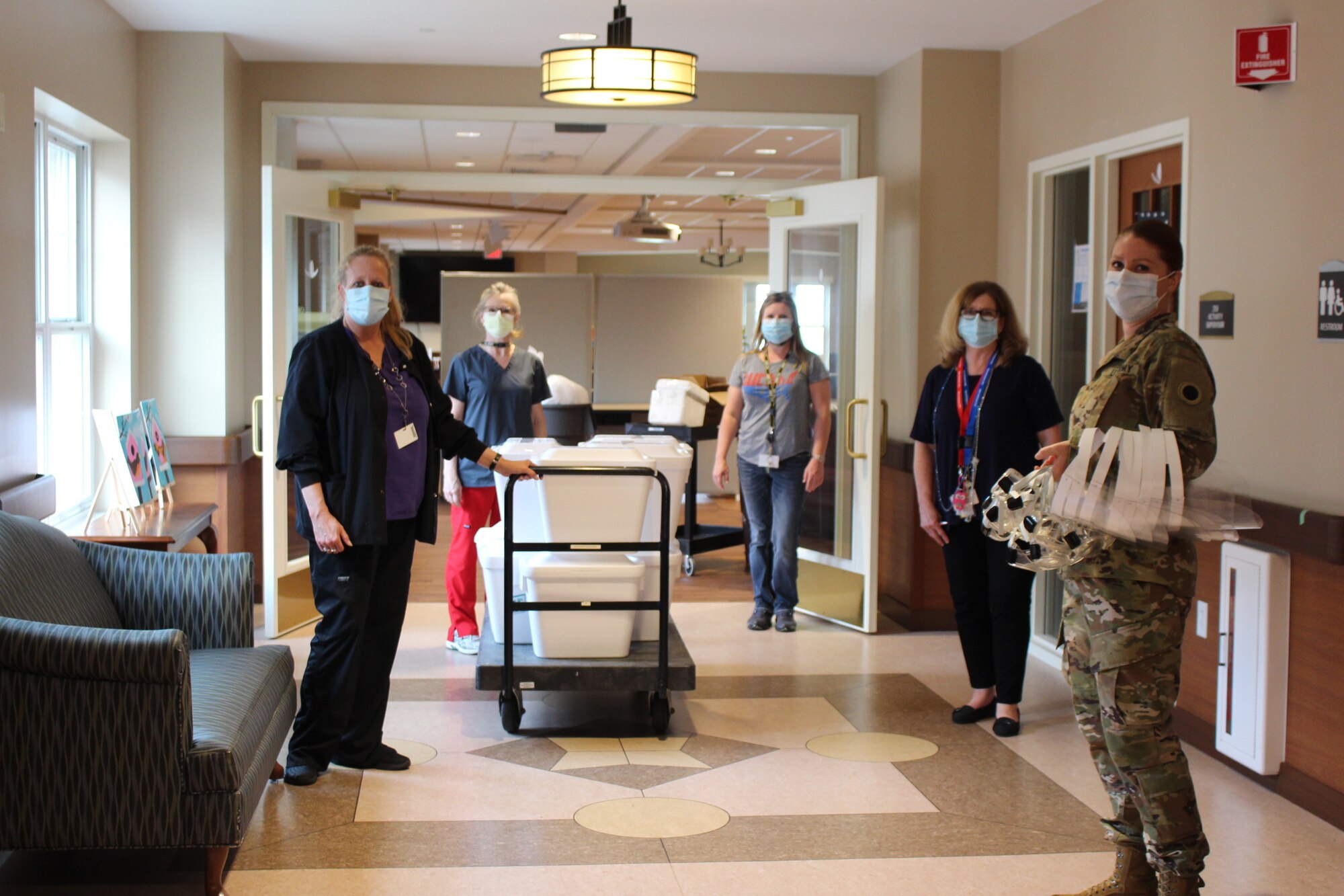 Maj. Jessica Taylor (right), commander of Company C, 237th Support Battalion, provides a supply of personal protective equipment to staff at the Ohio Veterans Home in Georgetown, Ohio. Taylor recently led a team of Ohio National Guard medical personnel that conducted COVID-19 testing at the facility, collecting samples from more than 200 staff members and approximately 140 resident veterans. (Photo courtesy of Ohio Department of Veterans Services)