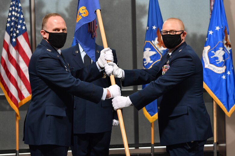 Col. Brian Kehl, 50th Mission Support Group commander, left, passes the guidon to Lt. Col. Andrew Cullen, 50th Civil Engineer Squadron commander, during the squadron’s change of command ceremony June 11, 2020, at Schriever Air Force Base, Colorado. As commander, Cullen is responsible for maintaining $1.2 billion in real property, ensuring suitable infrastructure and uninterrupted utilities in support of more than 190 Department of Defense satellites worth over $71 billion.  Before serving as the 50th CES commander, Cullen was the 502nd CE Group deputy commander at Joint Base San Antonio. (U.S. Air Force photo by Dennis Rogers)