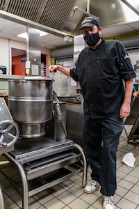 Mike Gilson, a kitchen assistant for Second Helpings, next to a tilt kettle that was filled with boiling beef stock that spilled all over his legs. Three Indiana National Guard medics helping out at Second Helpings during COVID-19 relief efforts jumped to his aid and treated his burns.