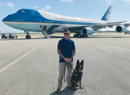 MAR-A-LAGO, Fla. – Staff Sgt. Danny Cohen, 21st Security Forces Squadron military working dog handler, and MWD Rexo, pose in front of Air Force One in Mar-A-Lago, Florida on Feb. 18, 2019. Cohen and Rexo were providing explosive detection for the United States presidential detail during their stay in Florida. (courtesy photo)
