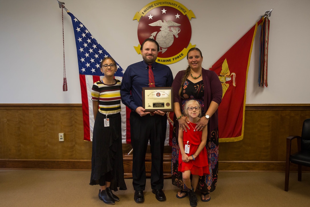 Chris Baker, deputy G-1 operations officer, his wife Jenice, and two daughters Kennidy and Avery, pose for a photo during an award ceremony at Camp Lejeune, N.C., June 11, 2020. Baker received the Civilian of the Year Award which is presented to a civilian working for the Marines Corps for their exceptional work and accomplishments over the past year. (U.S. Marine Corps photo by Lance Cpl. Nicholas Guevara)