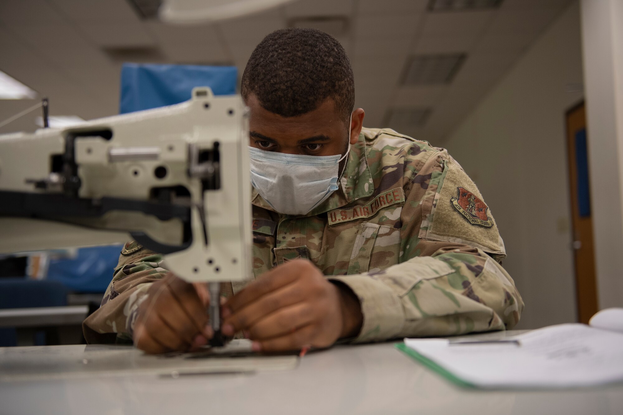 Aircrew Flight Equipment student adjusts the needle and needle bar on a 206RB Consew sewing machine