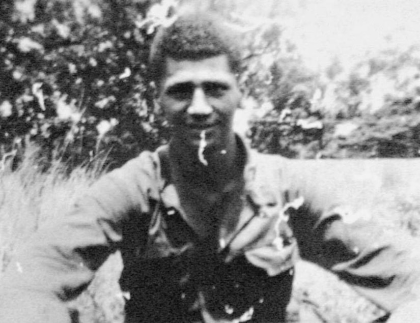 A man in a field smiles at a camera.