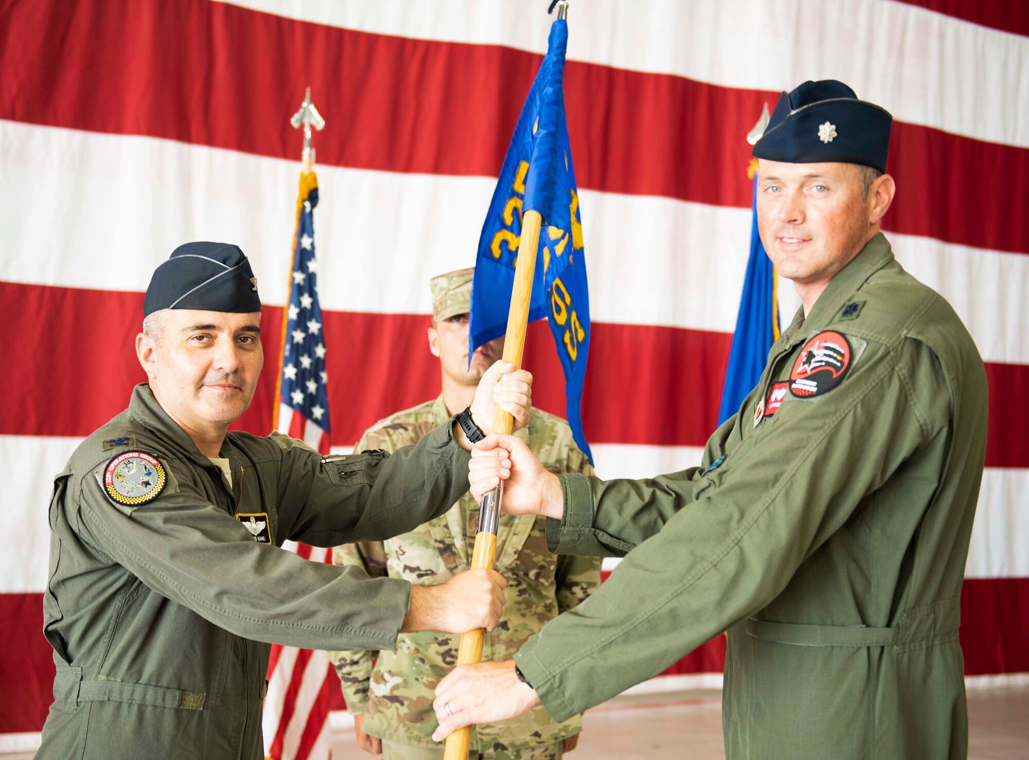 U.S. Air Force Col. Christian Kane, 325th Operations Group commander, left, awards command from U.S. Air Force Lt. Col. John Cummings, 325th Training Support Squadron commander, right, at Tyndall Air Force Base, Florida, on June 5, 2020. The 325th TRSS is responsible for conducting F-22 pilot academic and simulator training and F-15 flight simulators in support of air battle manager training. (U.S. Air Force photo by Airman Anabel Del Valle)