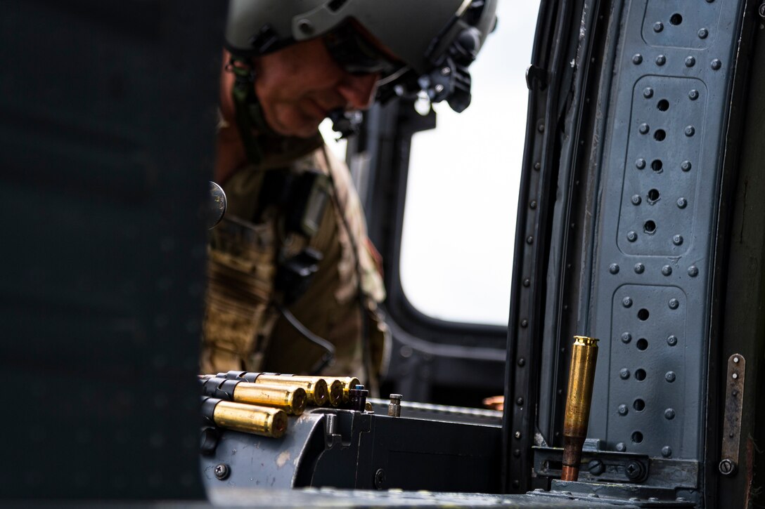 A photo of an Airman loading an M2 machine gun