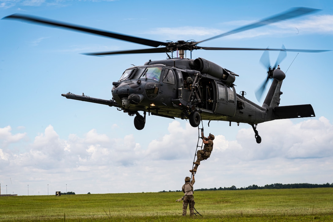 A photo of Airmen climbing a ladder into an HH-60G Pave Hawk