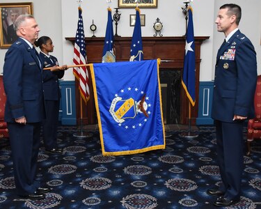 U.S. Air Force Chief Master Sgt. Christy Peterson, 11th Wing command chief, unfurls the 11th Wing flag while U.S. Air Force Maj. Gen. Ricky Rupp, Air Force District of Washington commander, and U.S. Air Force Col. Mike Zuhlsdorf, 11th Wing and Joint Base Anacostia-Bolling commander, stand at attention during the wing activation and assumption-of-command ceremony on Joint Base Anacostia-Bolling, Washington D.C., June 12, 2020. The 11th Wing -- The Chief’s Own was activated on the base in preparation for assuming host-wing responsibilities. The base will officially transfer from Navy to Air Force responsibility in October 2020. (U.S. Air Force photo by 1st Lt. Kali Gradishar)