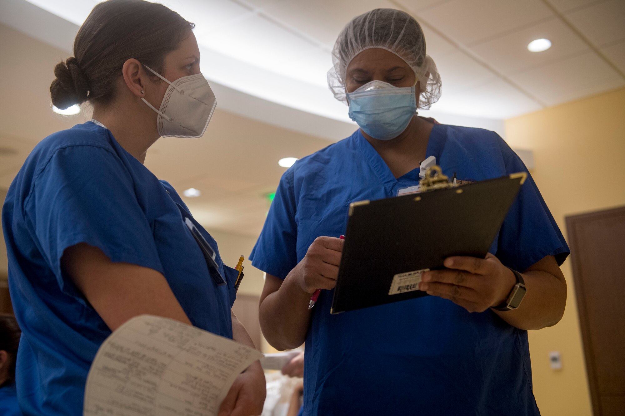Air Force Capt. Lisbeth Whaley (left), an emergency trauma nurse with Urban Augmentation Medical Task Force 811-1, receives instructions before starting her shift at Stamford Hospital-Bennett Medical Center, Stamford, Conn., May 14, 2020. U.S. Northern Command, through U.S. Army North, remains committed to providing flexible Department of Defense support to the Federal Emergency Management Agency for the whole-of-nation COVID-19 Response. (U.S. Air Force photo by Senior Airman Nicholas Dutton)