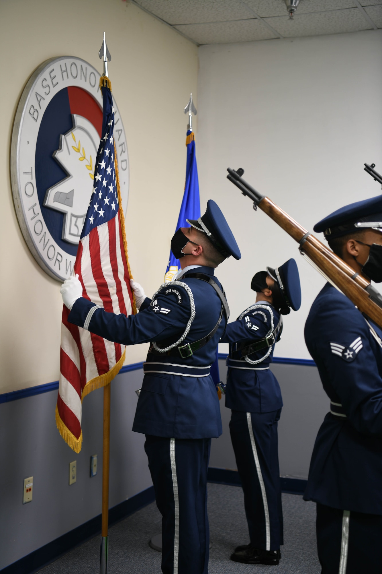 Photo shows two members of the Honor Guard placing the U.S. flag and Air Force flag in stanchions.