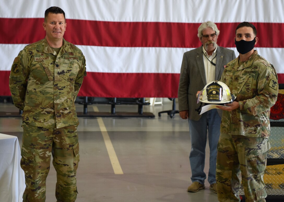 U.S. Air Force Lt. Col. Michael McCourt, 312th Training Squadron commander, presents Army Staff Sgt. Adam Santiago, 169th Engineer Battalion fire instructor, with the Department of Defense Fire Academy Instructor of the Year Award at the Louis F. Garland Department of Defense Fire Academy on Goodfellow Air Force Base, Texas, June 5, 2020. Each branch had one person chosen for the instructor of the year award and one member was chosen as the overall best instructor of the year. (U.S. Air Force photo by Airman 1st Class Ethan Sherwood)