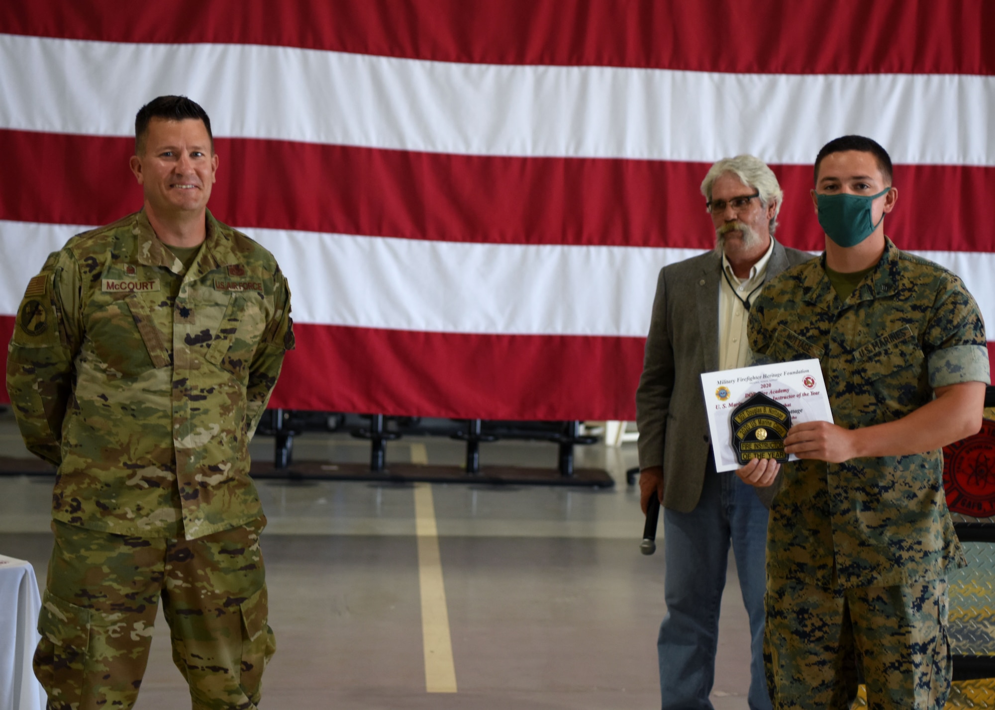 U.S. Air Force Lt. Col. Michael McCourt, 312th Training Squadron commander, presents Marines Staff Sgt. Douglas Nottage, Marine Corps detachment fire instructor, with the Department of Defense Fire Academy U.S. Marines Instructor of the Year Award at the Louis F. Garland Department of Defense Fire Academy on Goodfellow Air Force Base, Texas, June 5, 2020. Instructors are nominated by their peers and their leadership to receive the award. (U.S. Air Force photo by Airman 1st Class Ethan Sherwood)