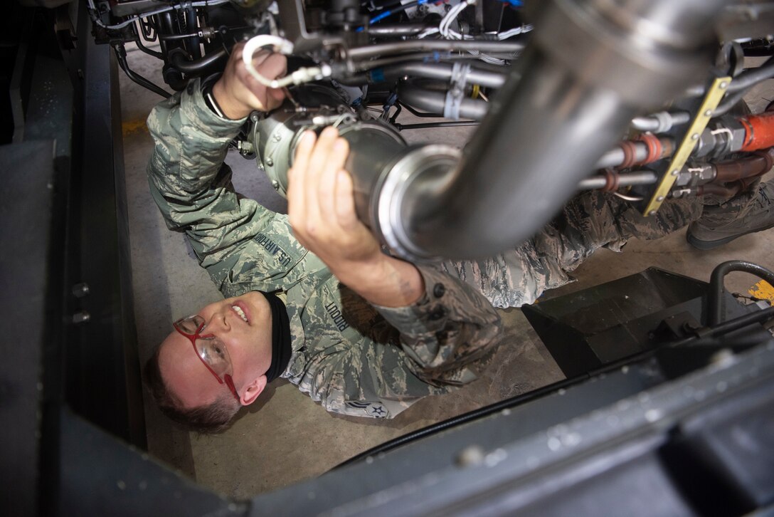 Airman 1st Class Eric Ridout, 100th Aircraft maintenance Squadron aerospace propulsion journeyman, examines the underside of an F108 turbofan engine at RAF Mildenhall, England, June 9, 2020. Jet propulsion Airmen are required to work in tight spaces to ensure the engines powering the 100th Air Refueling Wing’s KC-135 fleet remain in good condition.  (U.S. Air Force photo by Airman 1st Class Joseph Barron)