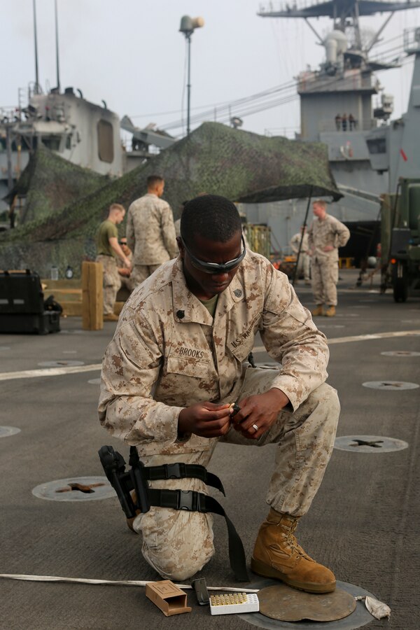 200610-M-CB805-1007 RED SEA (June 10, 2020) U.S. Marine Corps Staff Sgt. James Brooks, platoon sergeant, Weapons Platoon, Golf Company, Battalion Landing Team 2/8, 26th Marine Expeditionary Unit (MEU), loads a magazine prior to a pistol qualification range aboard the amphibious dock landing ship USS Oak Hill (LSD 51) June 10, 2020. Oak Hill with embarked 26th MEU is deployed to the U.S. 5th Fleet area of operations in support of naval operations to ensure maritime stability and security in the Central Region, connecting the Mediterranean and Pacific through the Western Indian Ocean and three critical chokepoints to the free flow of global commerce. (U.S. Marine Corps photo by Staff Sgt. Pablo D. Morrison)