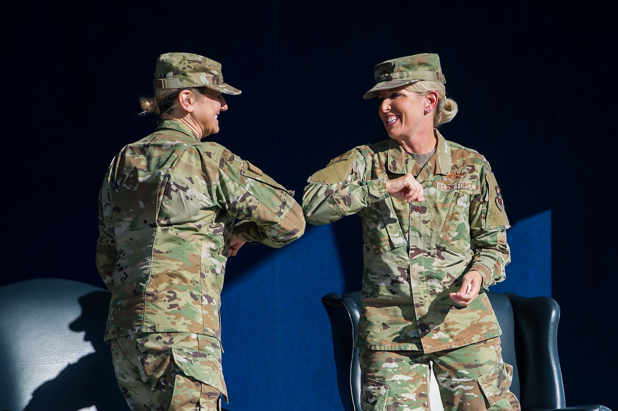 Brig. Gen. Caroline Miller, left, bumps elbows with Brig. Gen. Laura Lenderman during the 502d Air Base Wing and Joint Base San Antonio change of command ceremony June 12 at JBSA-Fort Sam Houston, Texas. Command of the unit passed from Lenderman to Miller during the ceremony.
