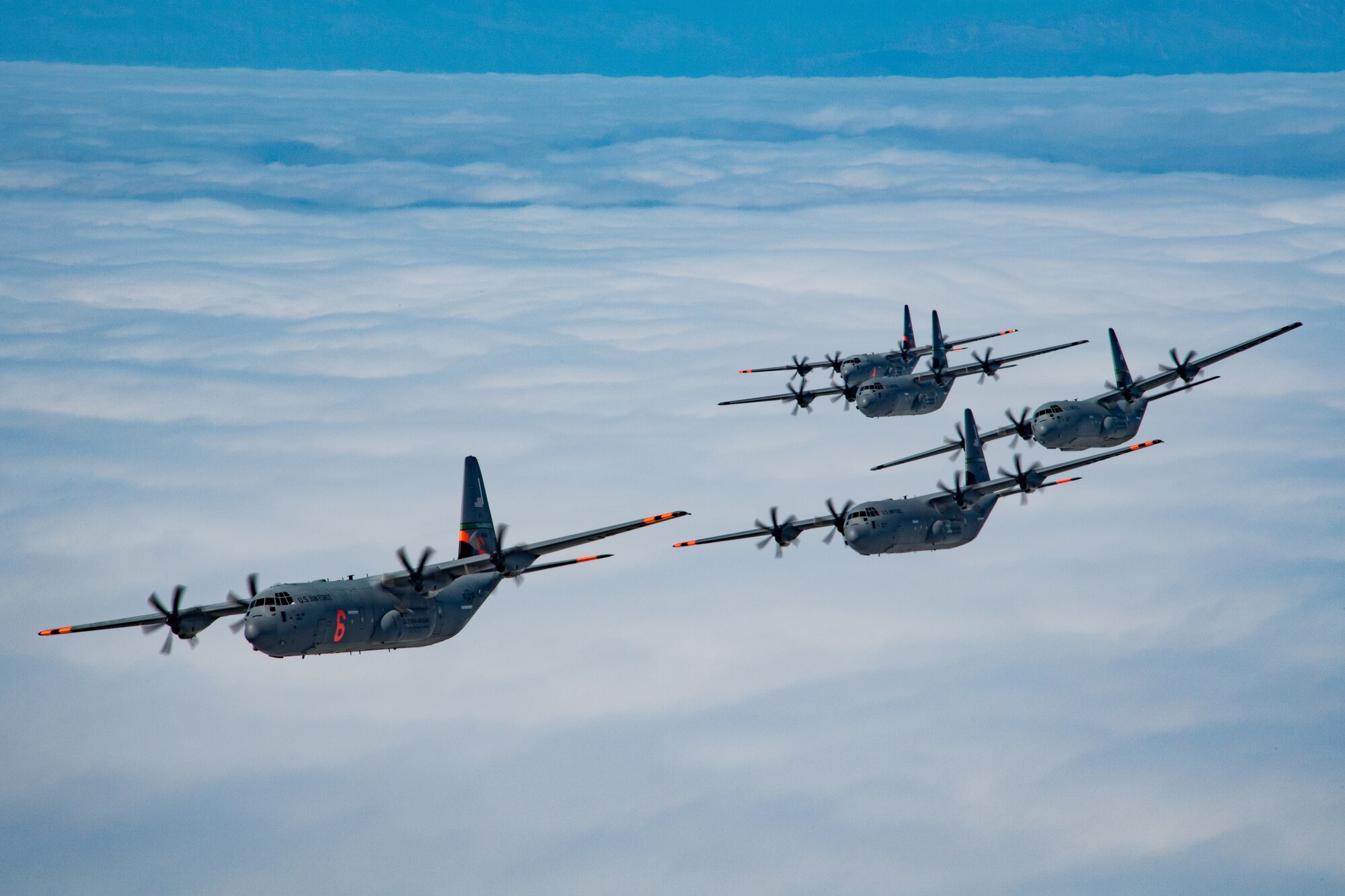 5 of 6 California Air National Guard C-130J Super Hercules aircraft fly in tight formation over the Pacific Ocean, California. May 27, 2020. California Air National Guard maintainers from the 146th Maintenance Group and aircrew from the 115th Airlift Squadron, collaborated to accomplish the launching of 6 C-130J Super Hercules aircraft for the first time in over 20 years U.S. Air National Guard by Tech. Sgt. Nieko Carzis.