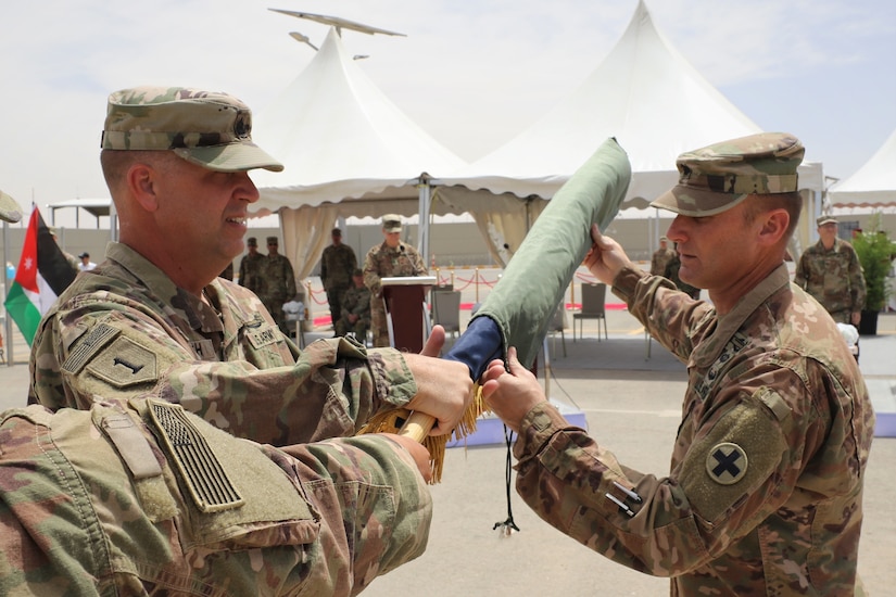 Lt. Col. Gregory Settle (right), Commander of the 2nd Battalion, 130th Infantry Regiment (2-130 IN), and Cmd. Sgt. Maj. Jeffrey Sowash (left), uncase their unit colors during the transfer of authority ceremony on Thursday.