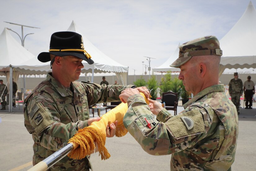 Lt. Col. Timothy Ozmer (right), Commander of the 1st Squadron, 303rd Cavalry Regiment (1-303 CAV), and Cmd. Sgt. Maj. John Hurt (left), case their unit colors during the transfer of authority ceremony