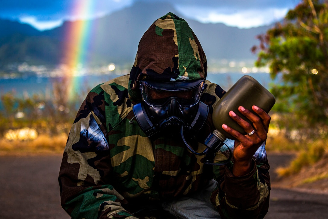 A U.S. Marine drinks water while in full mission oriented protective posture gear during a unit-held uphill run on Marine Corps Base Hawaii, June 11.