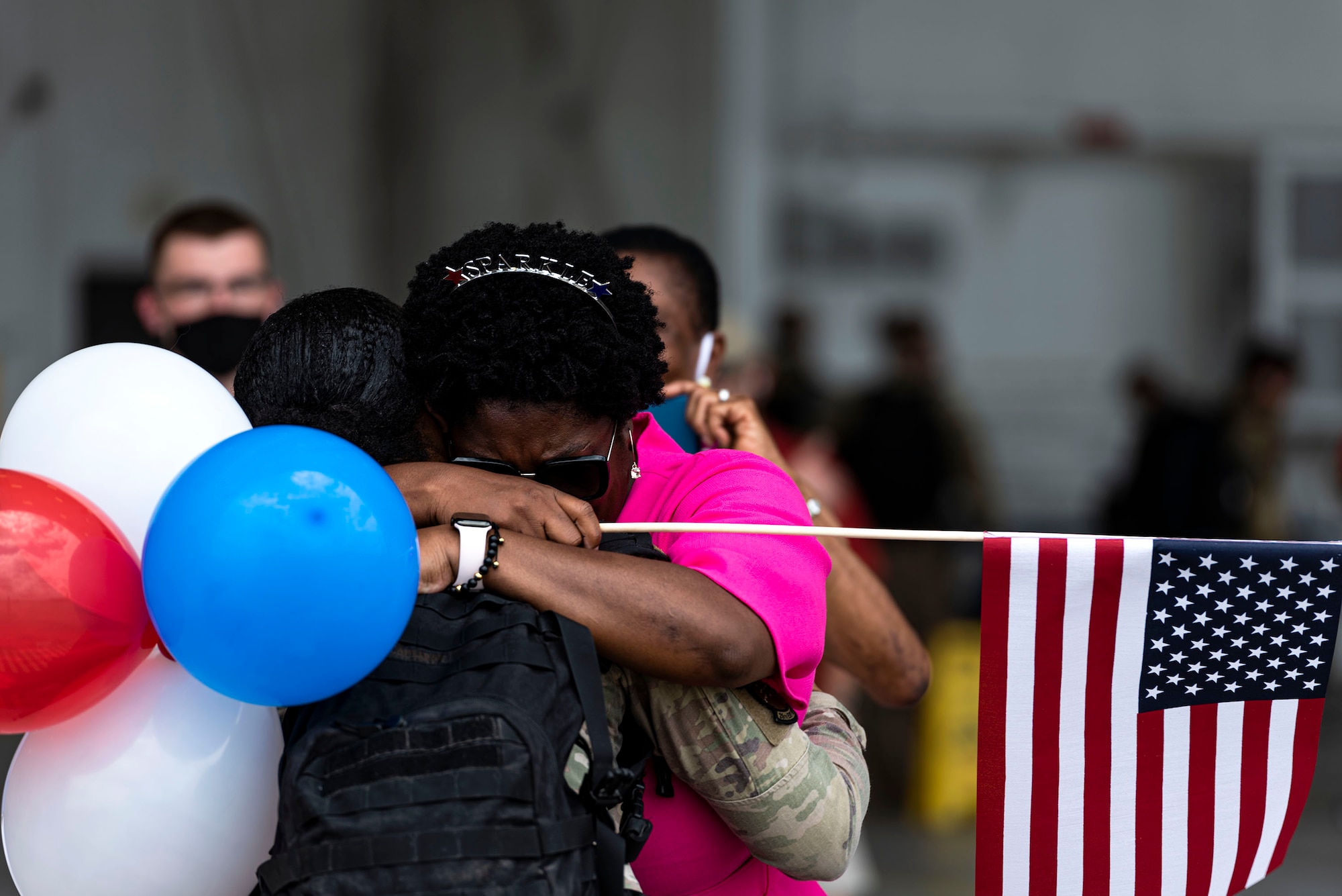 Photo of Airman hugging their family.