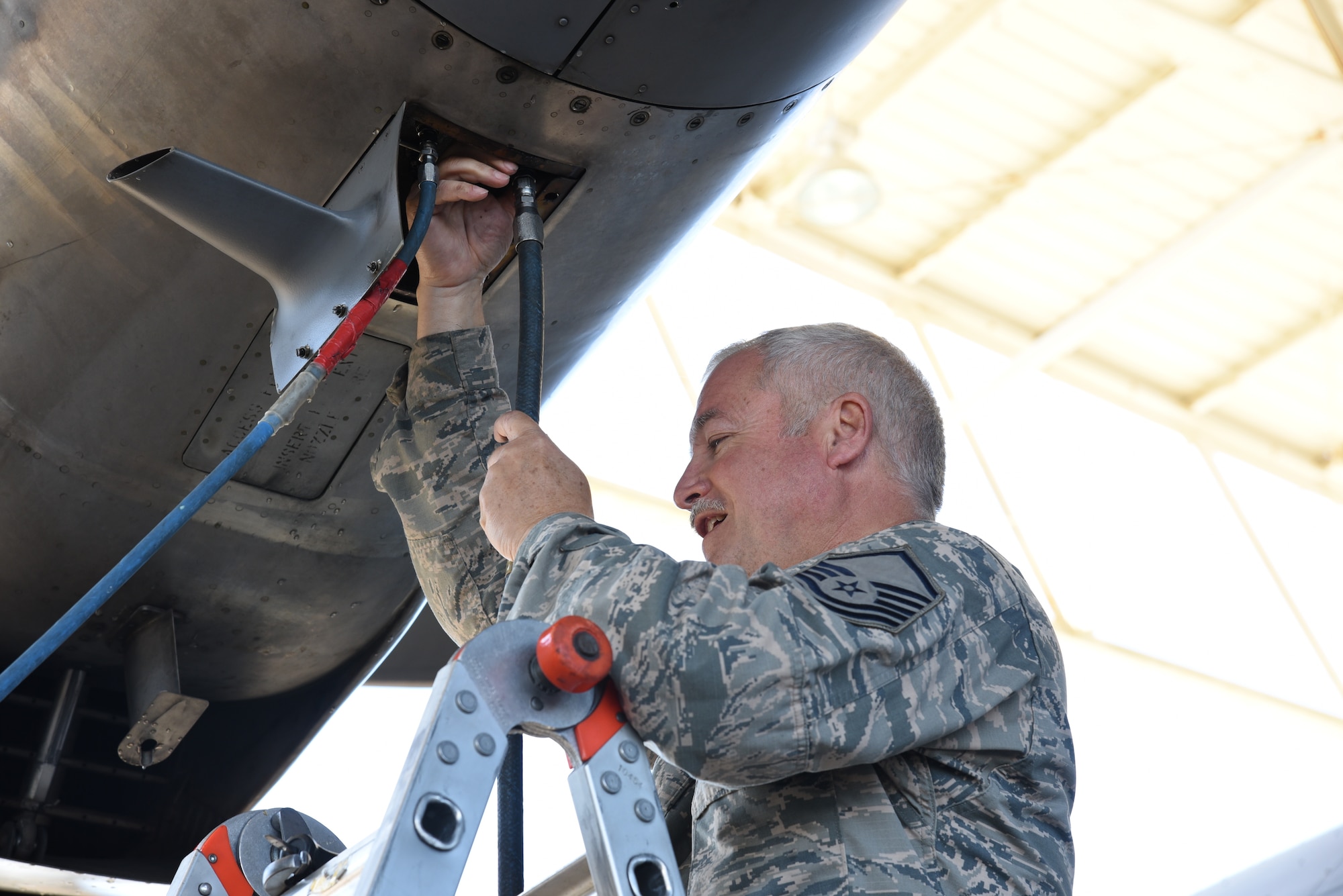 Master Sgt. Dave Desantis, 403rd Maintenance Squadron propulsion technician, attaches the air and water hoses to the engine compartment on an 815th Airlift Squadron C-130J Super Hercules to complete an Engine Compressor Wash before the aircraft goes for a "C" letter inspection in the Isochronal Dock at Keesler Air Force Base, Mississippi May 11, 2020. These inspections or letter checks can range from "A" five days basic check, "B" 18 days and more in depth, to "C" 22 days which is the most intrusive inspection; but are necessary to keep the aircraft maintained. (U.S. Air Force photo by Jessica L. Kendziorek)