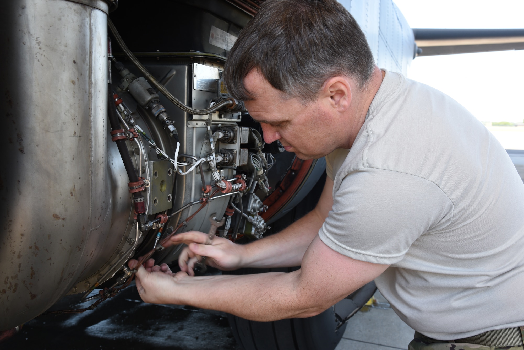 Tech. Sgt. Benjamin Cox ,403rd Maintenance Squadron propulsion technician, adjusts the bleed air line to prevent it from rubbing a hole, which could cause a bleed air leak and damage to the auxillary power unit before the Engine Compressor Wash on an 815th Airlift Squadron C-130J Super Hercules before the aircraft goes for inspection in the Isochronal Dock for a "C" letter inspection at Keesler Air Force Base, Mississippi May 11, 2020. These inspections or letter checks can range from "A" five days basic check, "B" 18 days and more in depth, to "C" 22 days which is the most intrusive inspection; but are necessary to keep the aircraft maintained. (U.S. Air Force photo by Jessica L. Kendziorek)