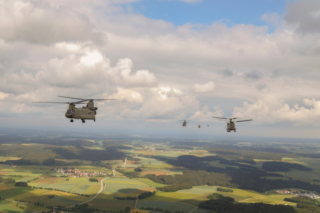 Army aircraft fly near one another.
