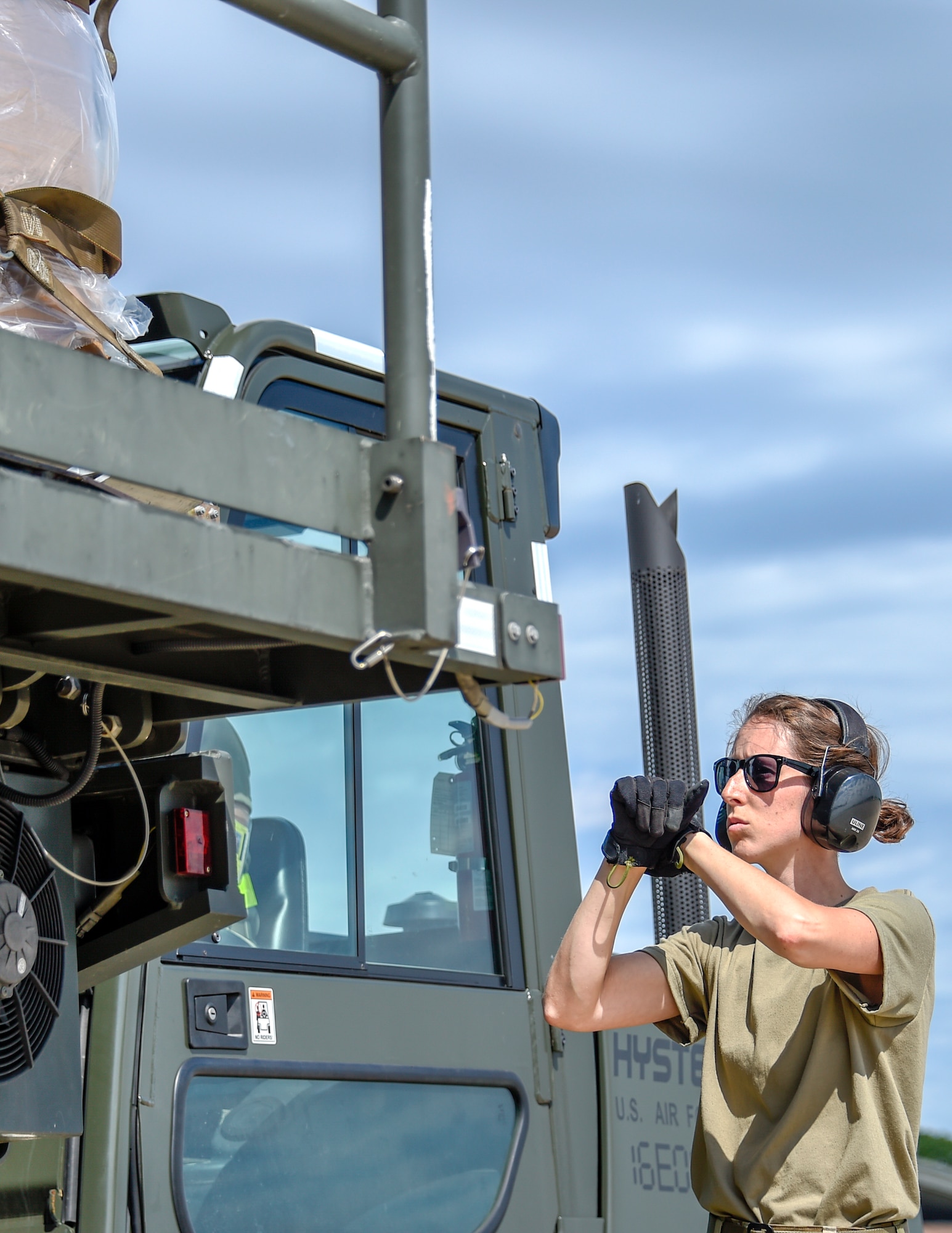 U.S. Air Force Tech. Sgt. Heather Boutin works with an Senior Airman Megan Lenling, both Air Transportation Specialists with the 133rd Airlift Wing’s Air Transportation Function to direct and onload palletized cargo from a forklift onto a C-17 Globemaster III during a recent Denton Humanitarian Assistance Program mission in St. Paul, Minn., June 13, 2020.