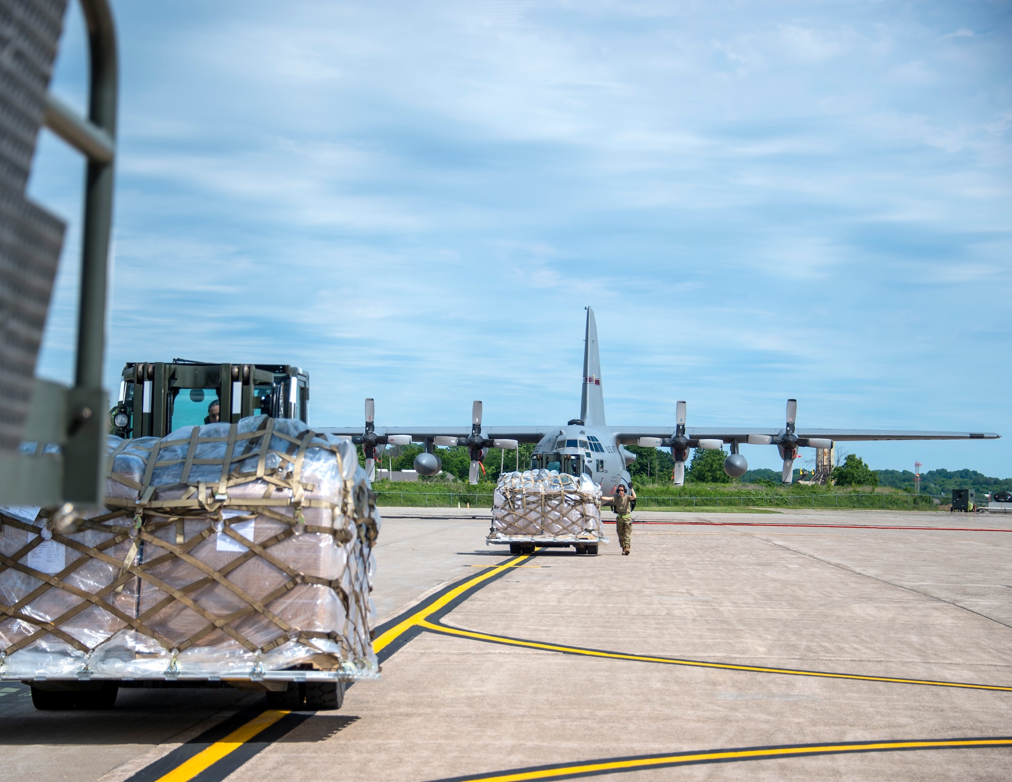 U.S. Air Force Tech. Sgt. Heather Boutin works with an Senior Airman Megan Lenling, both Air Transportation Specialists with the 133rd Airlift Wing’s Air Transportation Function to direct and onload palletized cargo from a forklift onto a C-17 Globemaster III during a recent Denton Humanitarian Assistance Program mission in St. Paul, Minn., June 13, 2020.