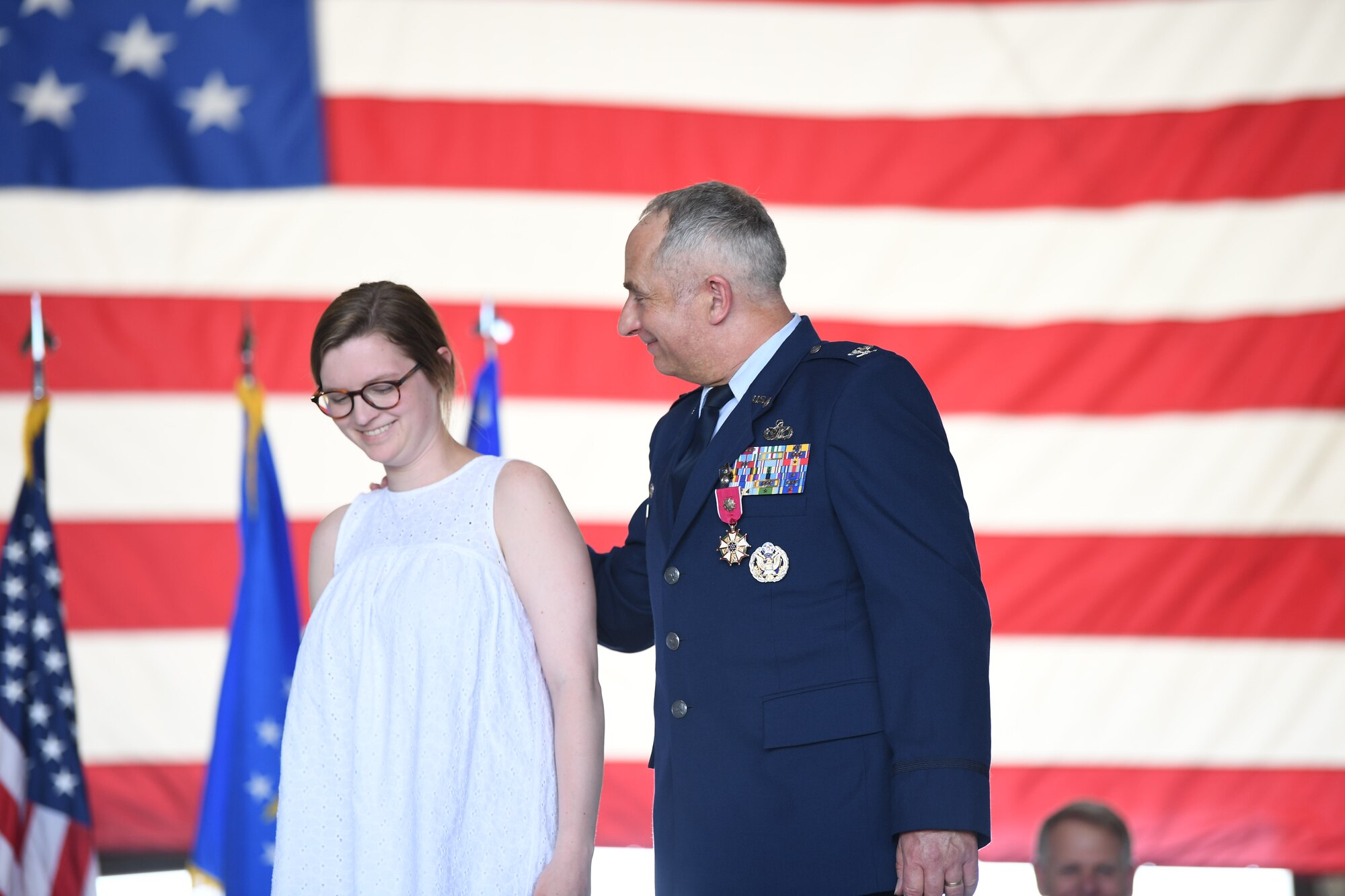 Col. Scott Russell, 434th Mission Support Group commander, walks across the stage with his daughter during his retirement ceremony at Grissom Air Reserve Base, Ind., June 6, 2020. Russell bid farewell to Grissom during his retirement ceremony, completing his 41-year Air Force career. (U.S. Air Force photo / A1C Harrison Withrow)