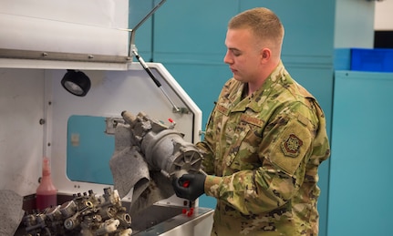 Airman 1st Class Mac Summers, an aircraft hydraulics technician assigned to the accessories flight in the 437th Maintenance Squadron, holds up an aircraft part on Joint Base Charleston, S.C., June 3, 2020.