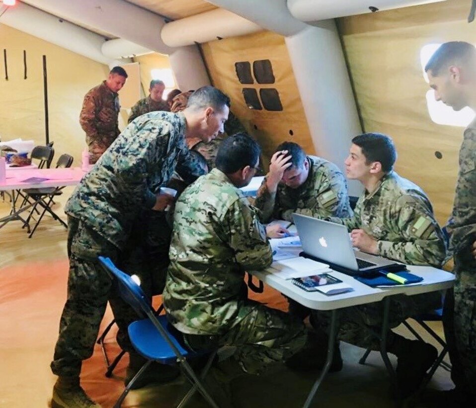 GySgt Alfonzo, LATAM Foreign Area SNCO, during an advisor mission with Chilean Marine Corps in Chile. GySgt Alfonzo explains Seabasing and other MEU Amphibious concepts to attentive Chilean Marine Corps Officers.