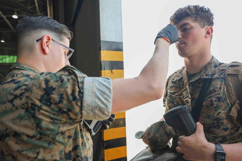 A U.S. Navy Corpsman with Special Purpose Marine Air-Ground Task Force-Crisis Response-Africa 20.2, Marine Forces Europe and Africa, takes the temperature of a U.S. Marine upon his arrival to Móron Air Base, Spain, on June 9, 2020. SPMAGTF-CR-AF 20.2 is deployed to conduct crisis-response and theater-security operations in Africa and promote regional stability by conducting military-to-military training exercises throughout Europe and Africa. SPMAGTF-CR-AF 20.2 continues to work closely with the relevant medical agencies and military organizations to minimize risk of COVID-19 exposure. (U.S. Marine Corps photo by Cpl. Tawanya Norwood)