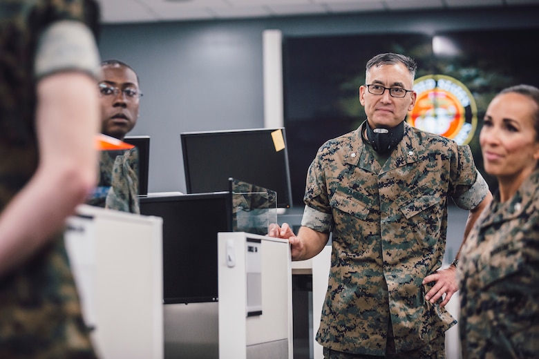 U.S. Marine Corps Lt. Col. Koichi Takagi, second from right, the assistant chief of staff G-6 for Marine Corps Installations - West, speaks to Marines at their workstations during a walkthrough at Marine Corps Base Camp Pendleton, California, June 4, 2020. 1st Network Bn., the first of six new Marine Corps network units, was created to improve oversight, command, and control of the Marine Corps enterprise network while managing building and local area networks around base. (U.S. Marine Corps photo by Staff Sgt. Donald Holbert)