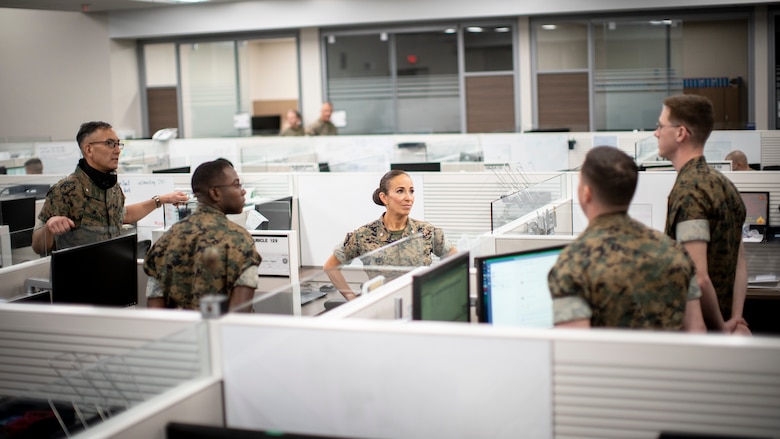 U.S. Marine Corps Lt. Col. Juliet Calvin, center, the commanding officer of 1st Network Battalion, Marine Corps Cyberspace Operations Group, speaks to Marines at their workstations during a walkthrough at Marine Corps Base Camp Pendleton, California, June 4, 2020. 1st Network Bn., the first of six new Marine Corps network units, was created to improve oversight, command, and control of the Marine Corps enterprise network while managing building and local area networks around base. (U.S. Marine Corps photo by Cpl. Dalton S. Swanbeck)