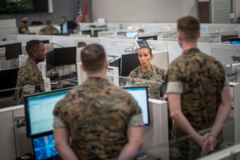 U.S. Marine Corps Lt. Col. Juliet Calvin, center right, the commanding officer of 1st Network Battalion, Marine Corps Cyberspace Operations Group, speaks to Marines at their workstations during a walkthrough at Marine Corps Base Camp Pendleton, California, June 4, 2020. 1st Network Bn., the first of six new Marine Corps network units, was created to improve oversight, command, and control of the Marine Corps enterprise network while managing building and local area networks around base. (U.S. Marine Corps photo by Cpl. Dalton S. Swanbeck)