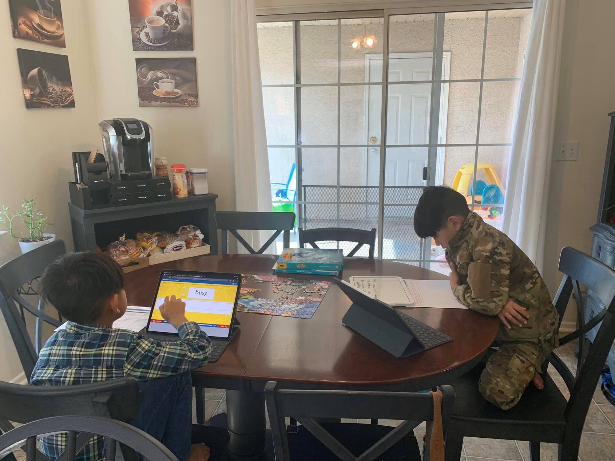 Cain and Eli Galbadores work on their distance learning assignments during COVID-19 April 27, 2020. Their mother, Yasmin Galbadores, runs a daycare program for mission-essential parents while also ensuring her own children receive proper education. (courtesy photo)