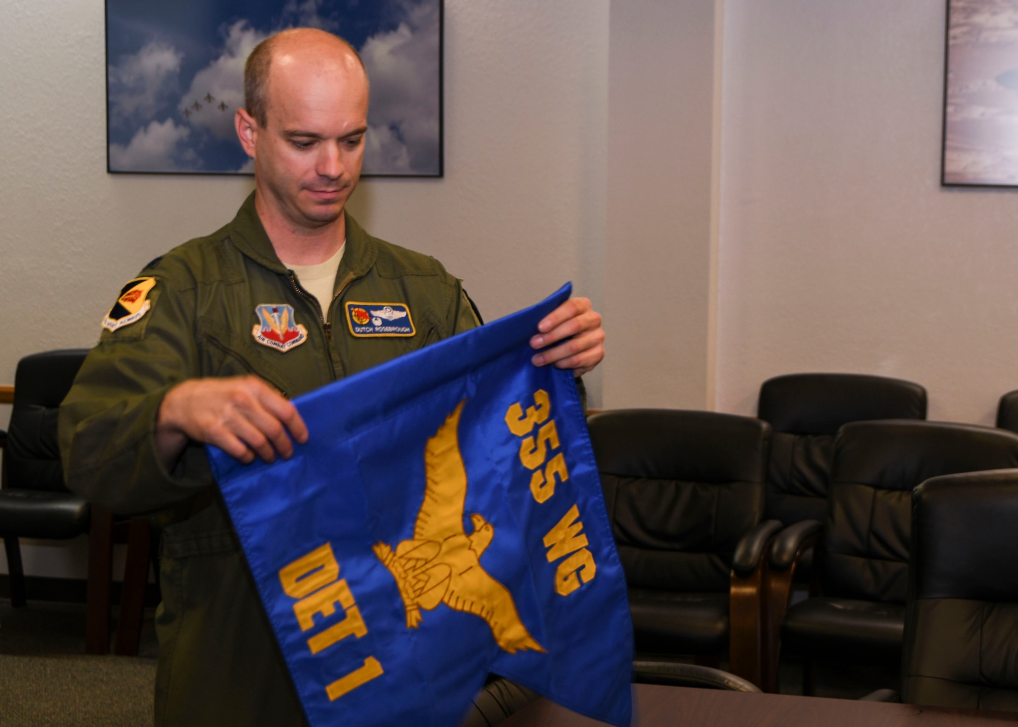 A photo of an Airman folding a squadron flag