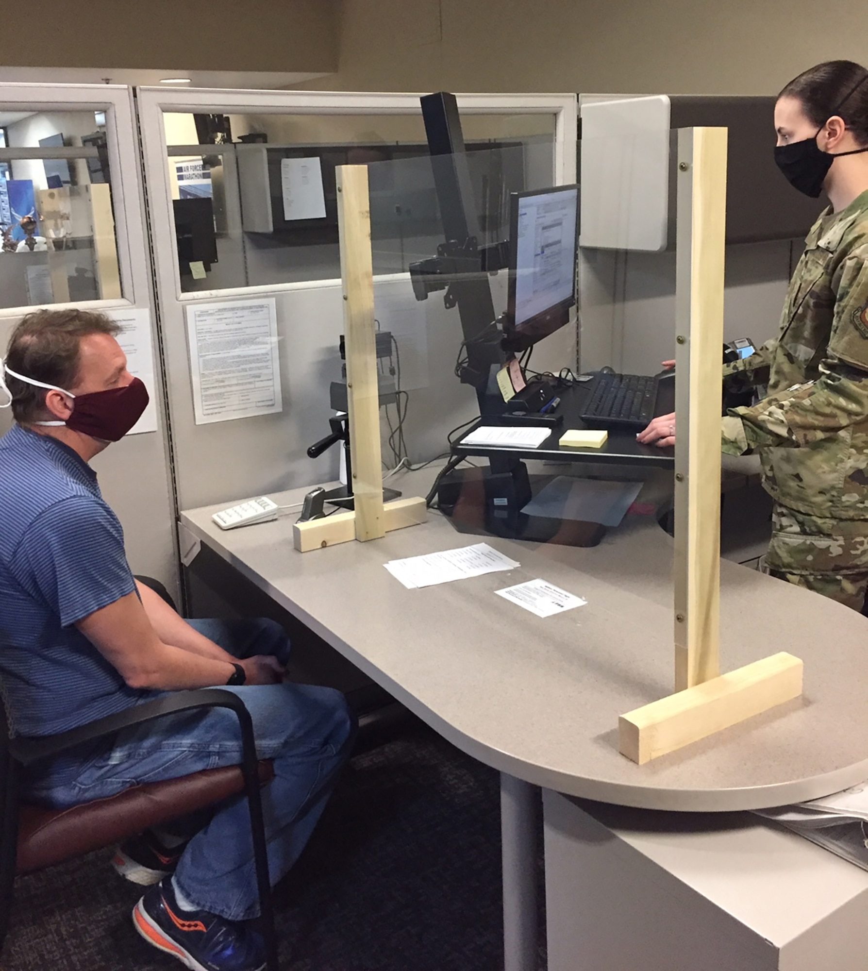 James Enderby, a biomedical engineer with the 88th Medical Group, is assisted by Airman 1st Class Elizabeth Bond, customer support technician, Military Personnel Flight, 88th Force Support Squadron, in obtaining a new common access card May 14 at Wright-Patterson Air Force Base. (Skywrighter photo/Amy Rollins)