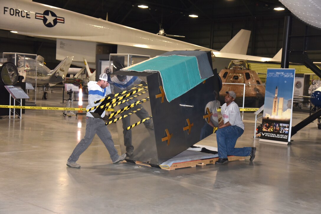 Museum exhibit specialists Taylor Burkhardt, left, and Quinton Johnson install the Global Positioning System (GPS) exhibit in the Space Gallery at the National Museum of the U.S. Air Force. (U.S. Air Force photo/Ken LaRock)