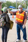 John Frisch of Norfolk Naval Shipyard’s Engineering and Planning Department is one of the civilian volunteers who perform temperature checks for employees coming onboard the shipyard.  “I wear my hardhat so people know I am one of them,” said Frisch. “They respect the job I am doing, many of them say ‘thank you.’ Several have mentioned they feel Norfolk Naval Shipyard really cares about keeping everyone working here safe!”