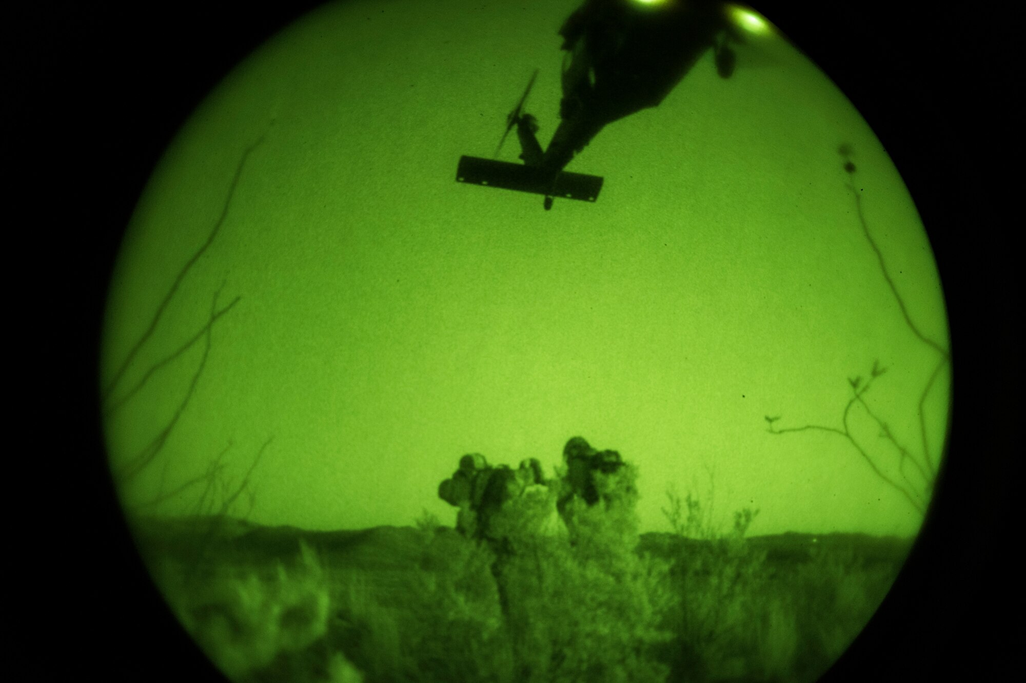 A photo of Airmen preparing to be picked up by a helicopter