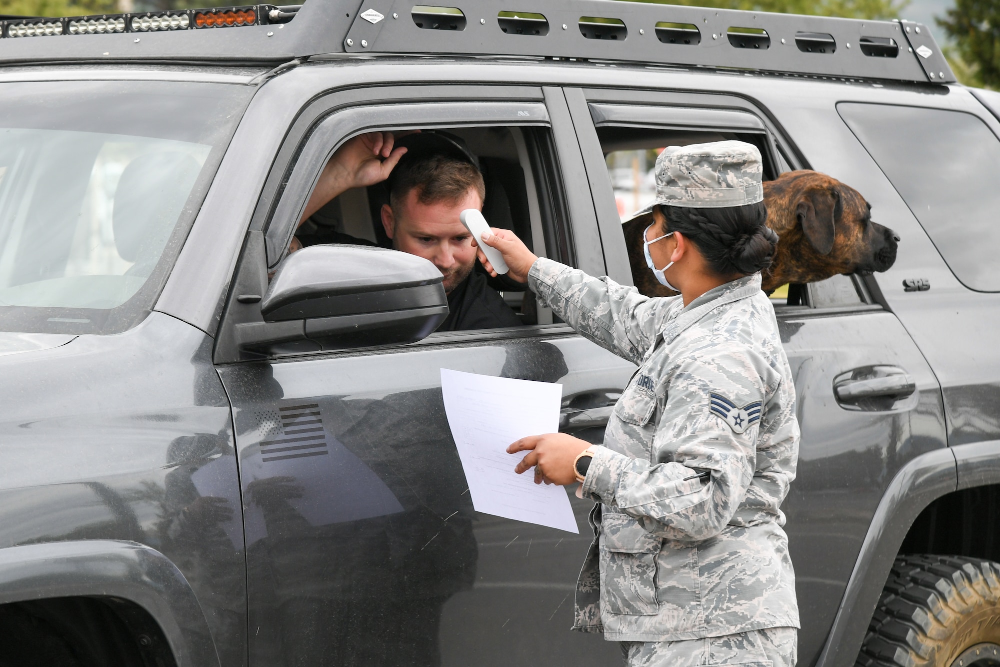 Tech. Sgt. Charles Fulland, 421st Fighter Squadron, has his temperature checked by Senior Airman Jazmine Brunner, 75th Medical Group, during a medical screening.