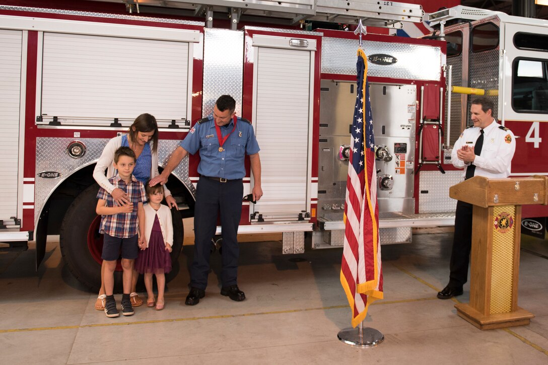 Lee Joyce, 423rd Civil Engineer Squadron lead firefighter, is awarded the Fire Department’s Life Saving Medal at RAF Alconbury, England, June 16, 2020, for saving his daughter’s life. Lee utilized his firefighter training to assist his four-year-old daughter when she was chocking on a chocolate egg May 16, 2020. (U.S. Air Force photo by Airman 1st Class Jennifer Zima)