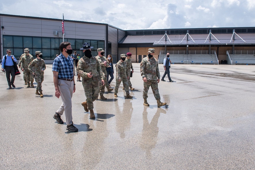 U.S. Air Force Master Sgt. Geoffrey Wadsworth (center), 737th Training Support Squadron military training instructor, briefs U.S. Secretary of Defense Dr. Mark T. Esper (left) during a tour of the Pfingston Reception Center June 16, 2020, at Joint Base San Antonio-Lackland, Texas. Esper met with AETC leaders to see firsthand how Basic Military Training is fighting through COVID-19 with health protection measures in place and adapting operations to current Centers for Disease Control and Prevention Guidance. The visit also allowed him to witness how a citizen becomes an Airman during COVID-19. (U.S. Air Force photo by Sarayuth Pinthong)